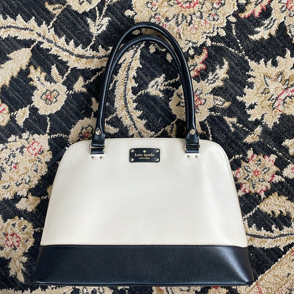 Kate Spade black and cream purse. Red lining. Pen marks in pocket shown in pics.